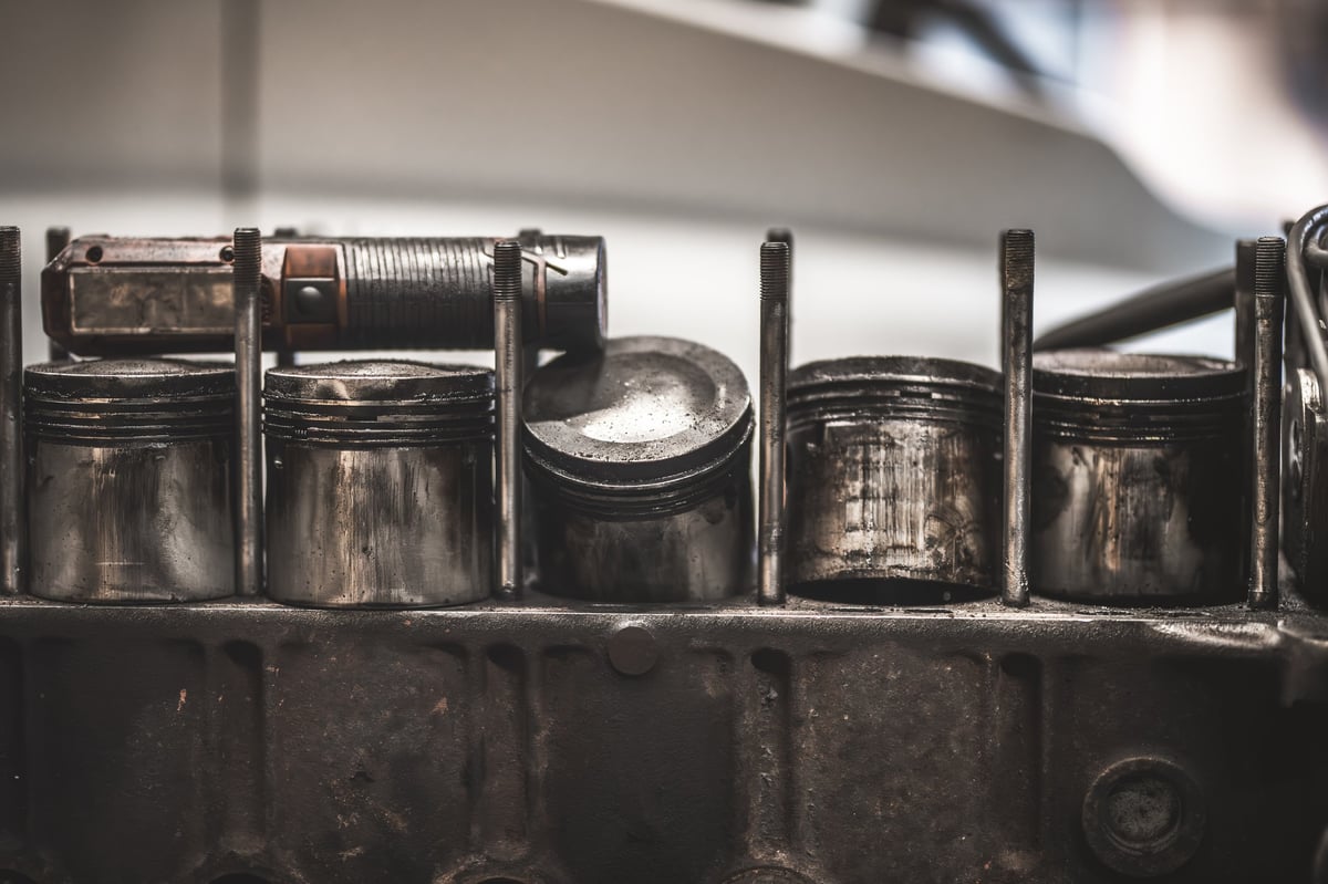 Detailed shot of aged automotive engine components, showcasing the wear and tear of mechanical parts in a workshop setting